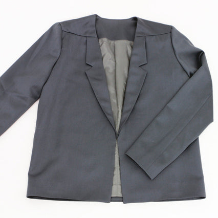Gray wool gabardine blazer with notch lapels and gray lining displayed flat, showing relaxed open-front silhouette