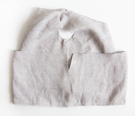 Uniform Tunic in natural linen showing waistline seam joining bodice right side out to skirt wrong side out