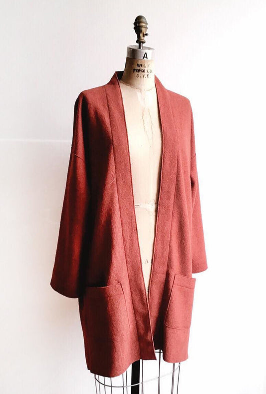 Rust-red boiled wool open-front Tessuti Berlin Jacket with patch pockets on dress form against a white background