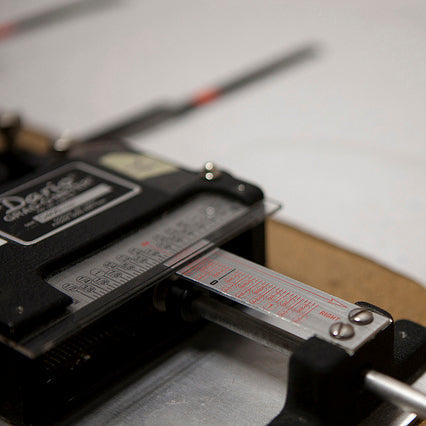 Close-up of pattern grading machine and measurement tool on sewing pattern pieces for pocket tank design