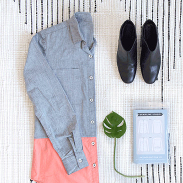 Archer Button Up in chambray and coral colorblock, with black ankle boots, monstera leaf, and pattern envelope
