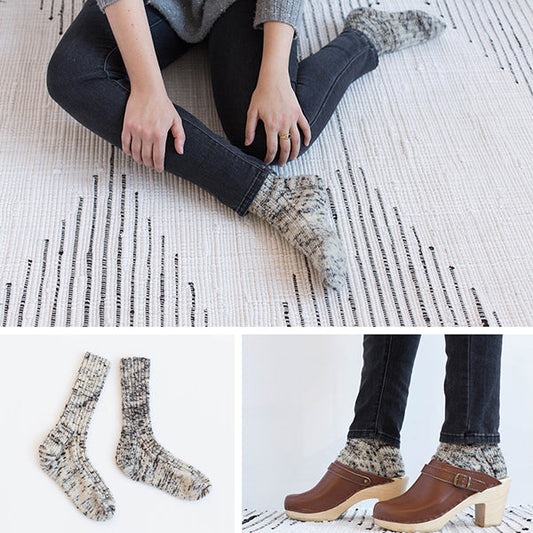 Cream and black marl handknit socks shown three ways: worn seated on a rug, as a flat lay, and styled with brown clogs
