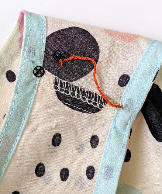 Willow Tank in black polka dot with light blue binding, showing bra strap keeper with orange thread chain and black snaps