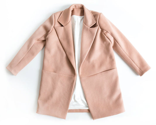 Yates Coat in blush wool with notched lapels and long sleeves, displayed flat lay with white Kashi lining visible