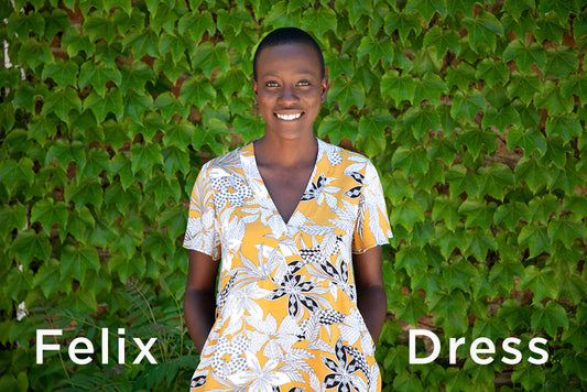 Felix Dress sewing pattern in yellow and white floral print with short sleeves and eased waist skirt, against green ivy wall