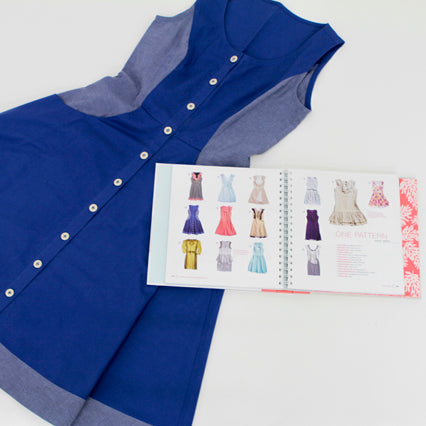 Navy blue button-up dress with chambray collar and armholes alongside open BurdaStyle book showing dress pattern illustrations and fabric swatches