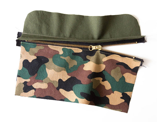 Portside Dopp Kit assembled side panel showing olive canvas and camo pocket piece with brass zipper, not yet attached to bag