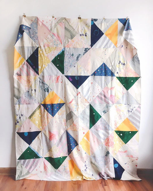 Triangle-pieced quilt in Nani Iro double gauze in navy, yellow, green, pink, and cream, from a Fancy Tiger Crafts tutorial