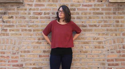 Linden Sweatshirt View B in burgundy French terry with cropped length, worn with black pants against brick wall