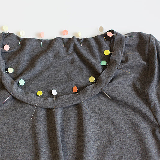Charcoal gray Lark Tee with scoop neckline and neckband, pinned with flower-head pins showing neckline finishing technique