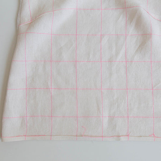 Willow Tank in white linen with neon pink windowpane weave, shown wrong side out with hem folded up for hemming
