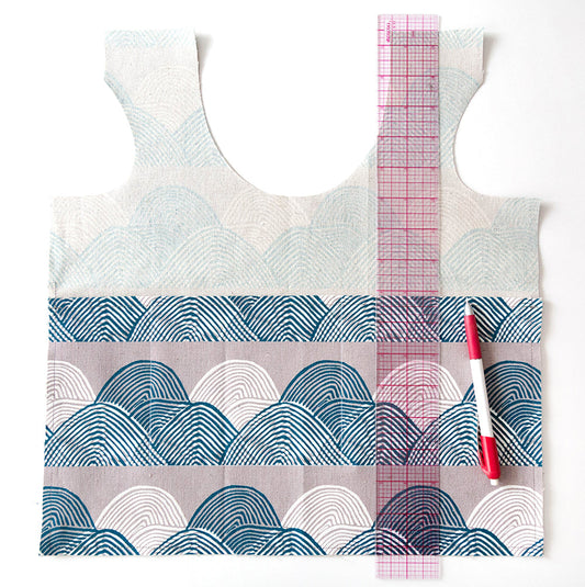 Stowe Bag in wave print fabric with pink grid ruler and chalk pencil marking in pocket divider stitching lines