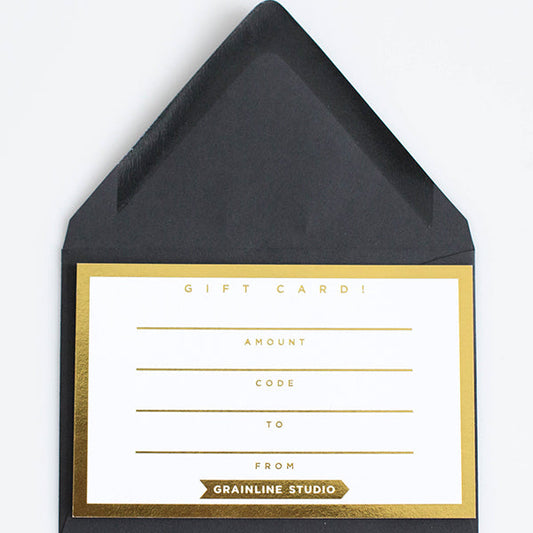 Grainline Studio gift card with black envelope and gold border, blank fields for amount, code, to, and from