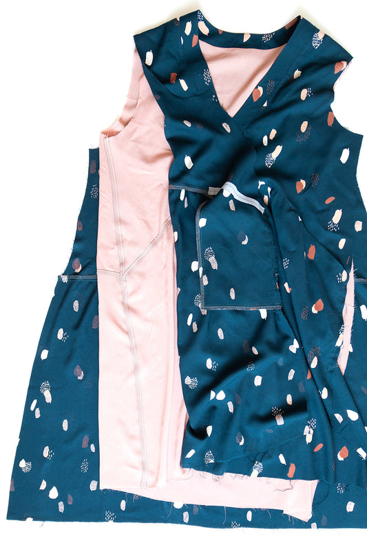 Felix Dress in teal abstract print with pink lining, showing interior construction with side seams open and lining exposed