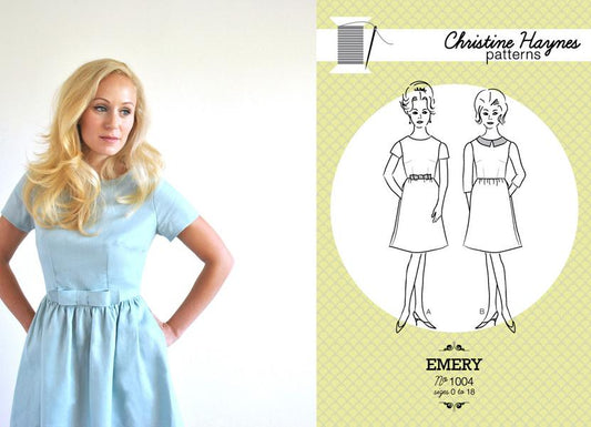 Woman in light blue Emery dress with gathered waist and bow belt, alongside Christine Haynes Patterns Emery pattern envelope
