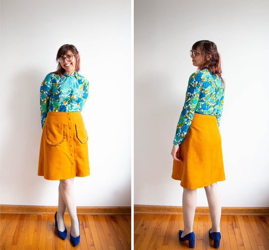 Front and back views of Reed Skirt in mustard with button front and ruffled pockets, paired with blue floral blouse