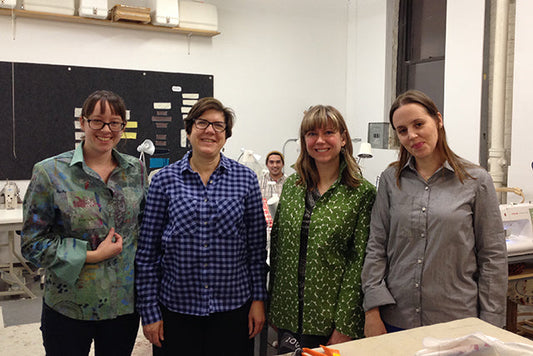 Four people wearing completed Archer Button-Up shirts in floral, gingham, green print, and gray fabrics at a sewing class
