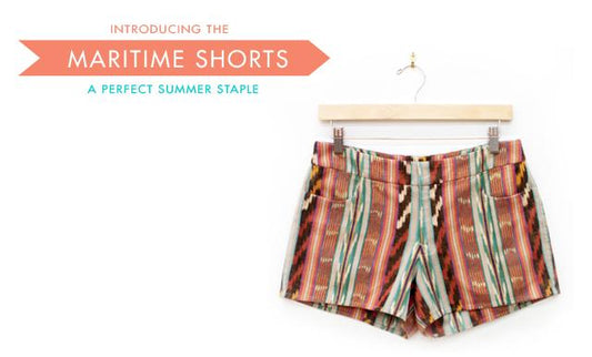 Maritime Shorts in rust and teal ikat striped fabric on wooden hanger, with Introducing the Maritime Shorts text overlay