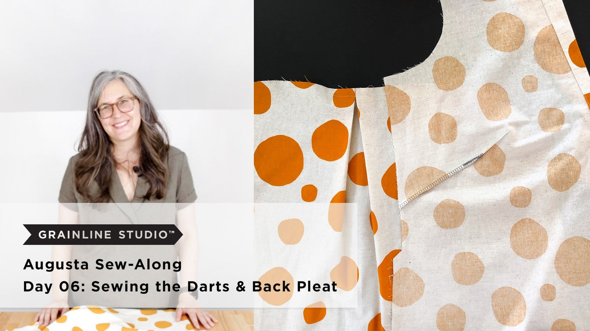 Woman smiling beside a mustard dot Augusta back with a stitched pleat and a front with a serged dart on a black background