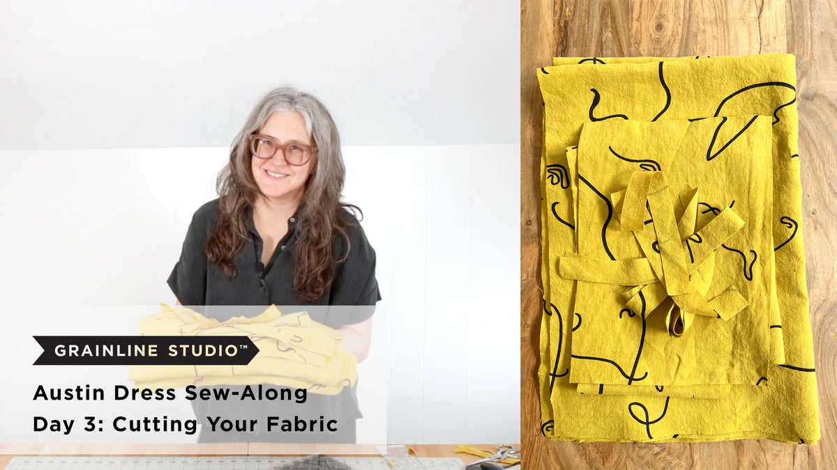 Jen holding cut Austin Dress fabric pieces next to a flat lay of yellow abstract print linen yardage on a wood surface