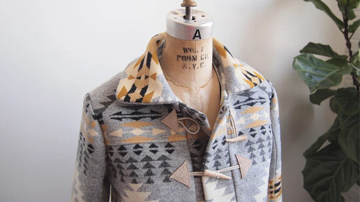 Completed Cascade Duffle Coat in geometric print wool on dress form showing collar, toggle closures, and patch pockets
