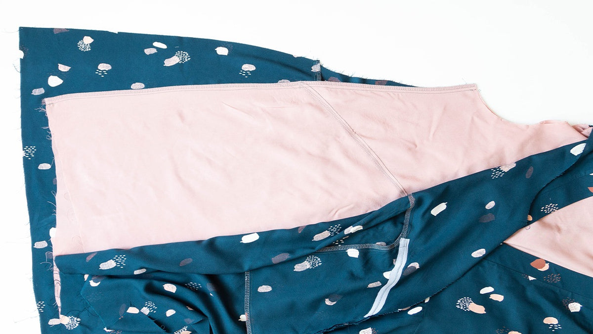 Felix Dress side seams sewn showing teal abstract print self fabric with pink lining and serged seam allowances