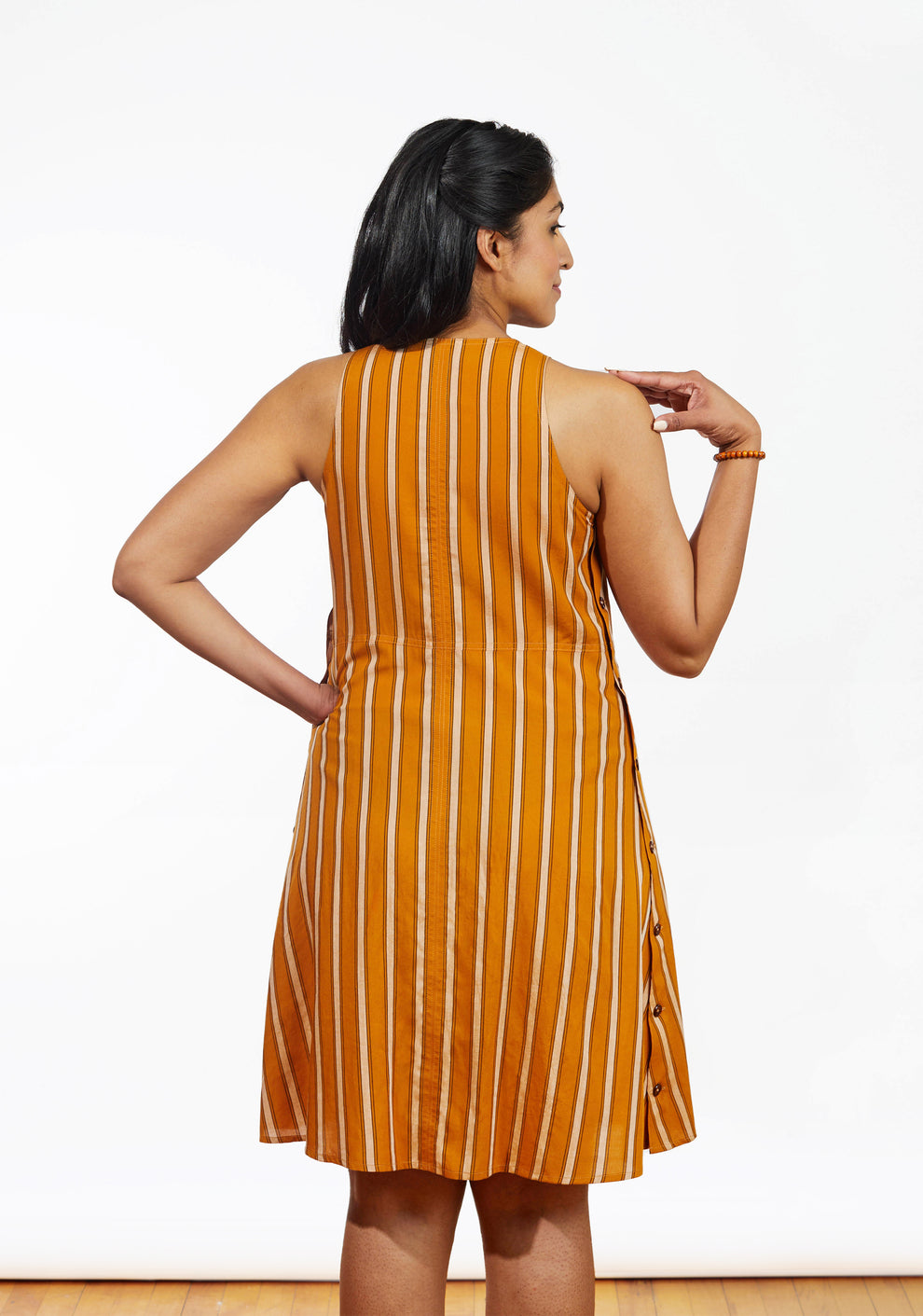 Close-up of Austin Dress button placket along side seam in orange stripe rayon.