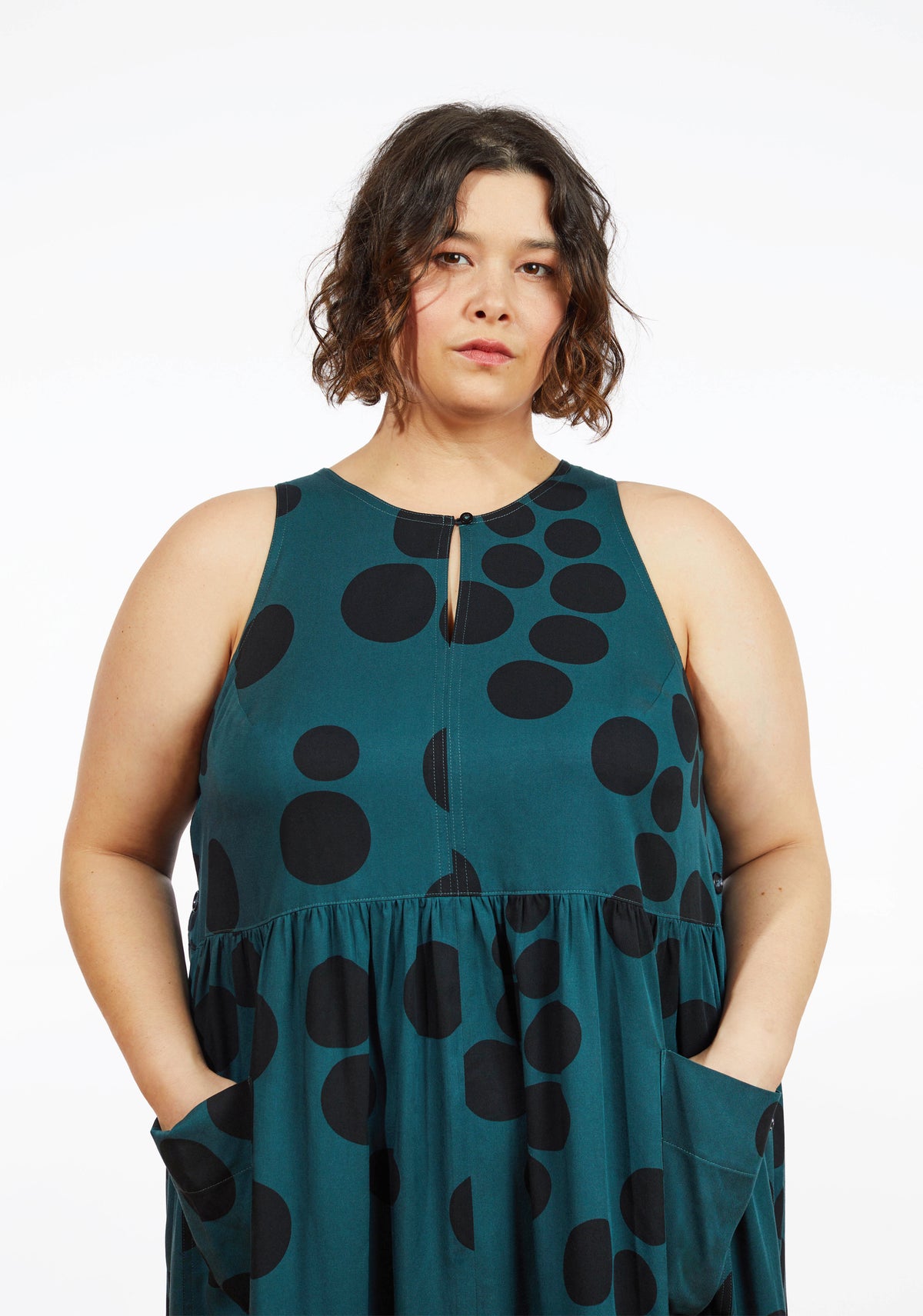 Close up of neckline and bodice on Austin Dress in teal dot print showing keyhole opening and sleeveless design.