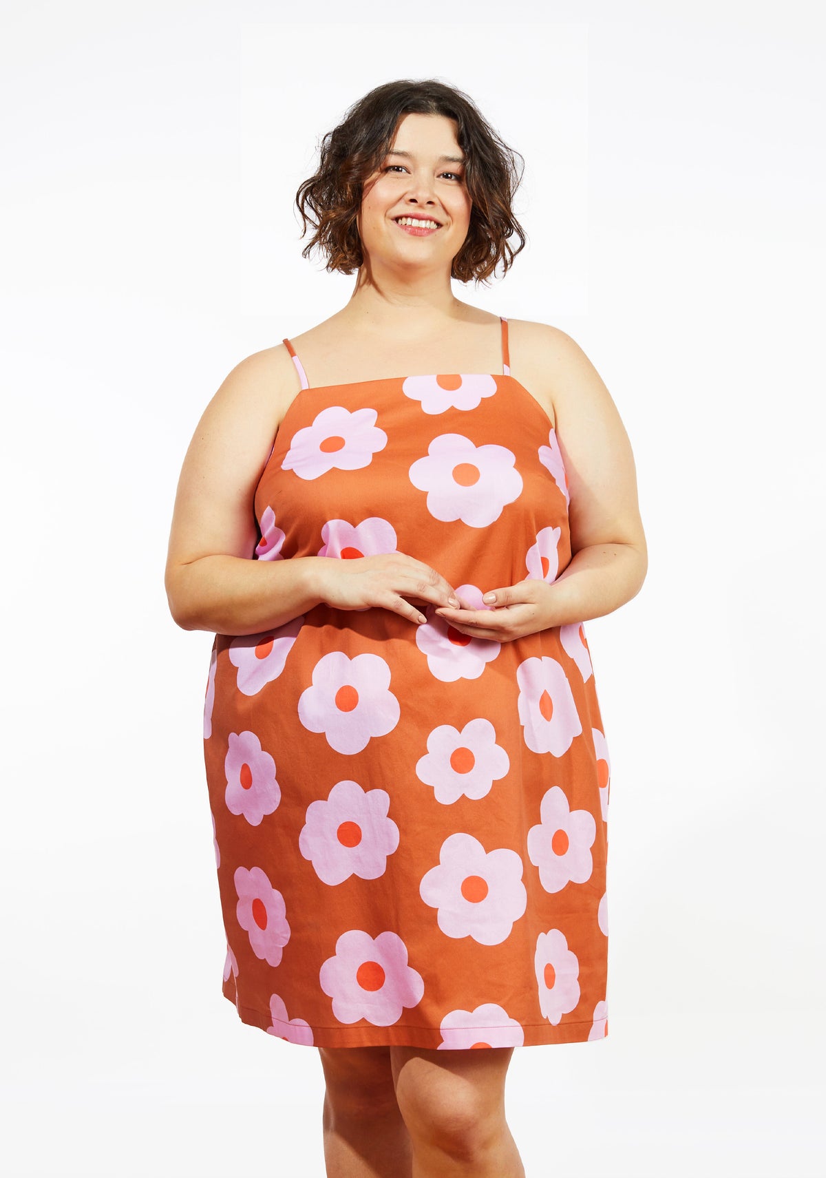 Front view of smiling model wearing floral Myra Dress with spaghetti straps and straight neckline.