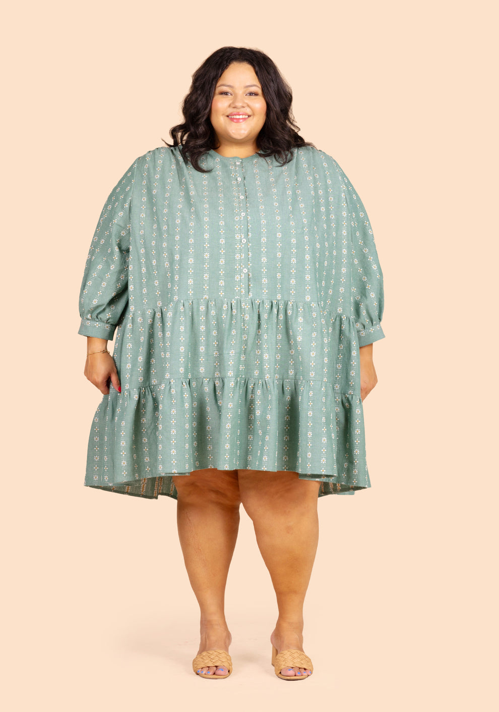 Front view of model wearing short Poppy Dress View C in green floral with long sleeves.