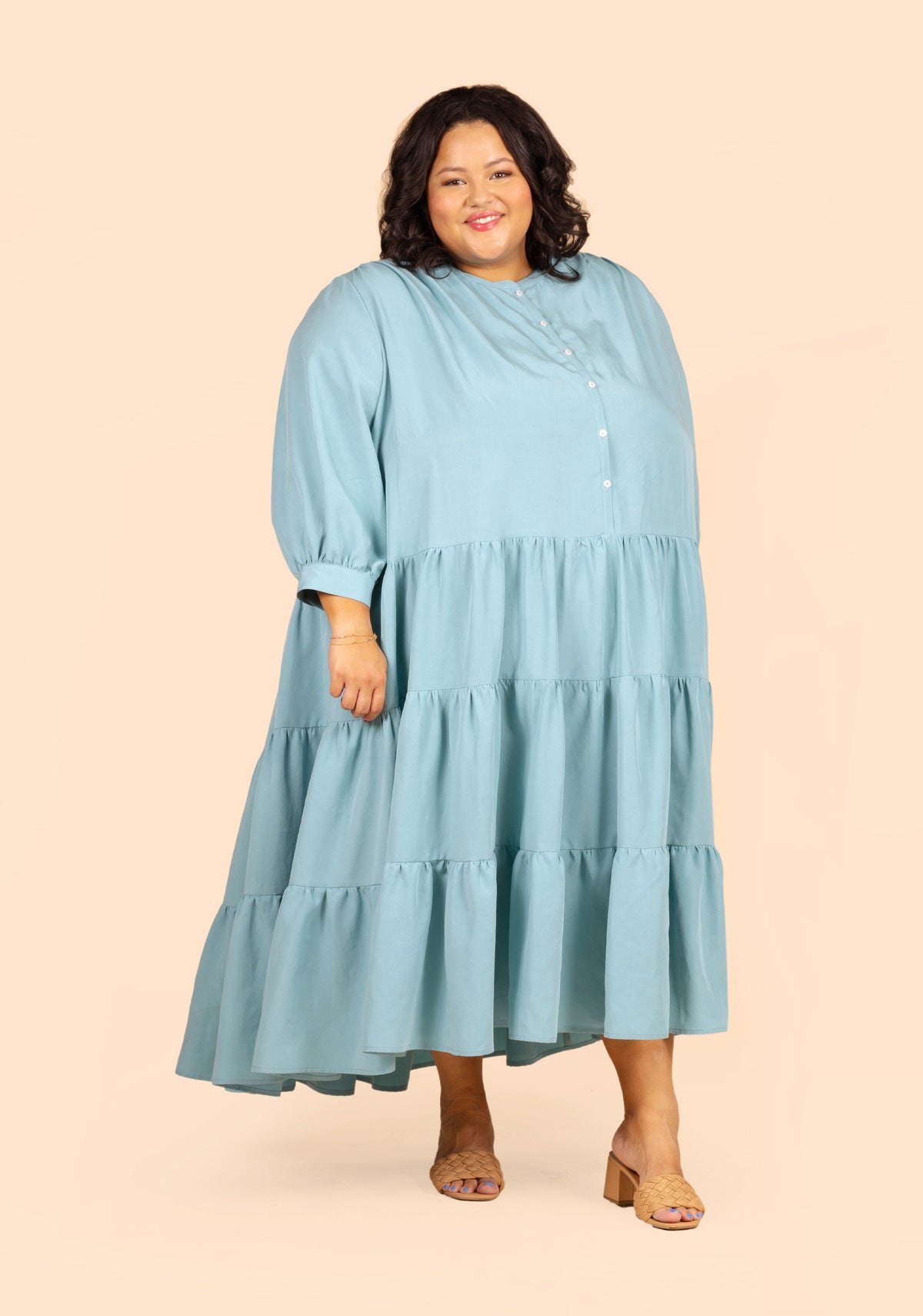 Front view of long Poppy Dress View D with gathered skirt and full sleeves in light blue fabric.
