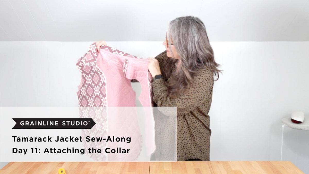 A quilted Tamarack jacket body in pink floral print held up from the neckline showing the inside lining and shoulder seams on a white background