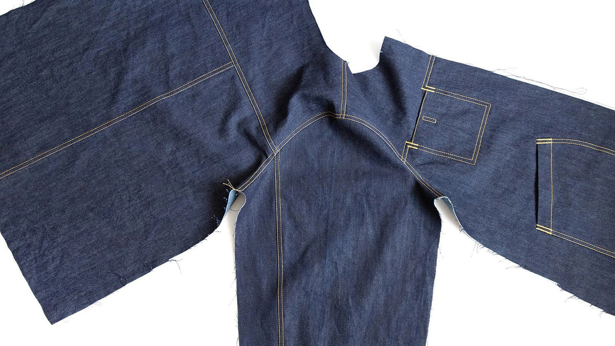Thayer Jacket in navy denim showing shoulder seams, two-piece sleeves set flat, and continuous side seams with topstitching