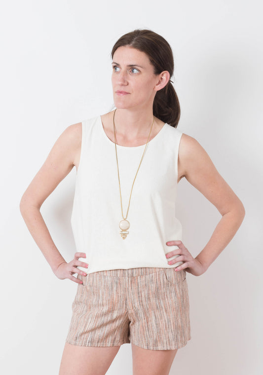 Front view of model wearing striped Grainline Maritime Shorts with a sleeveless ivory top.