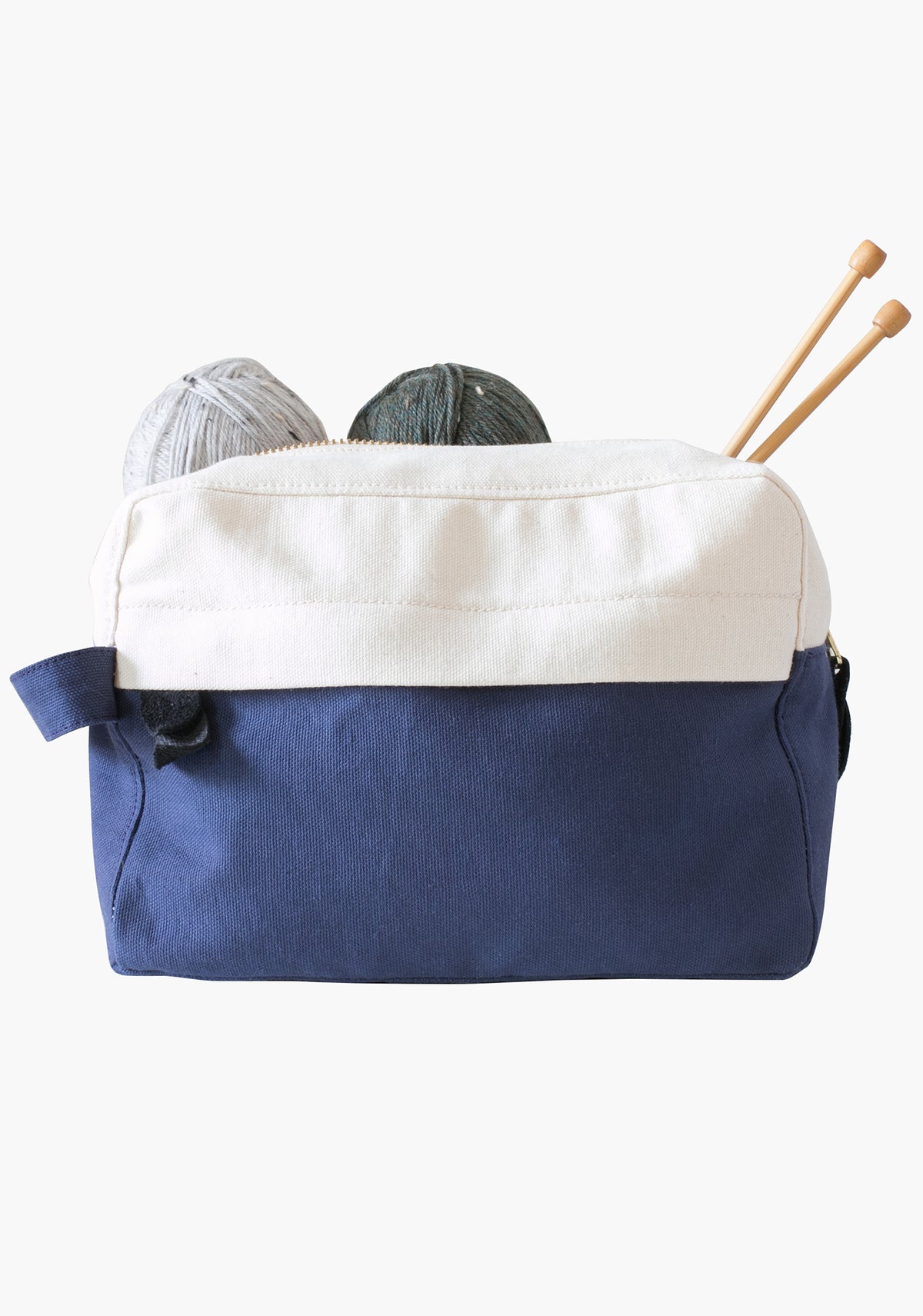 Portside dopp kit in blue and natural canvas shown holding yarn and knitting needles.