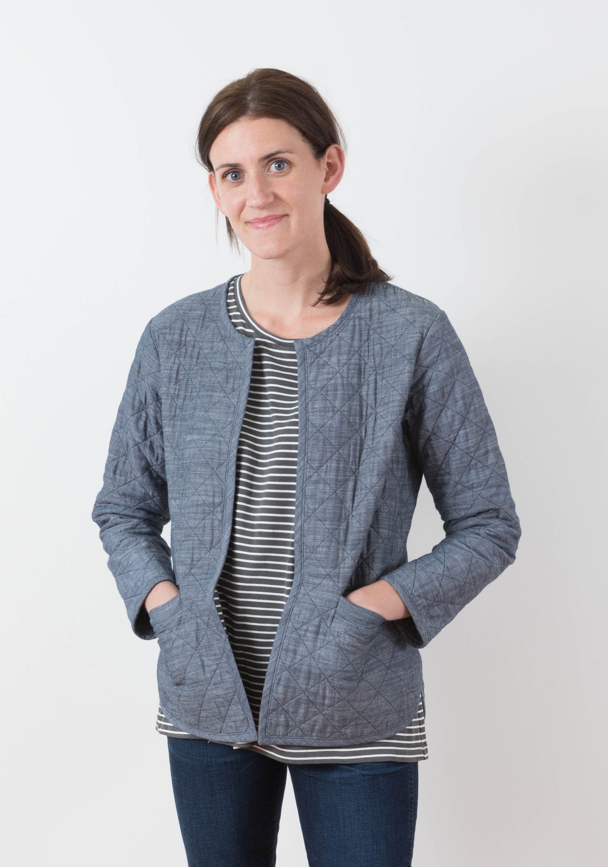 Model: Size 6, 5'8" | Front view of blue diamond quilted Tamarack Jacket in View A worn open over striped shirt and jeans.