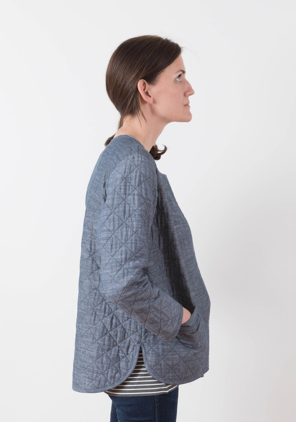 Side view of blue quilted Tamarack Jacket in View A with curved hem and relaxed silhouette.