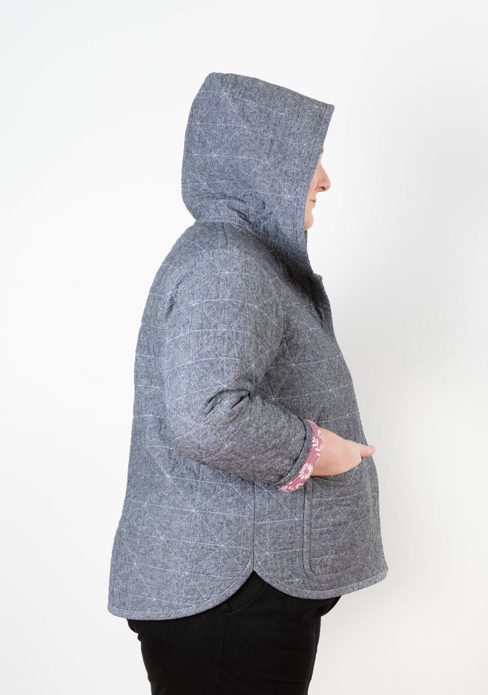 Side view of gray Tamarack Jacket with hood up, pink floral cuff lining visible, size 0-32.
