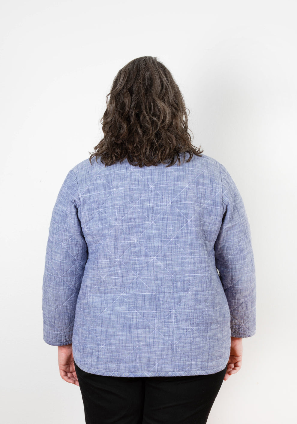 Back view of Tamarack Jacket in blue chambray with diamond quilting pattern and relaxed fit.
