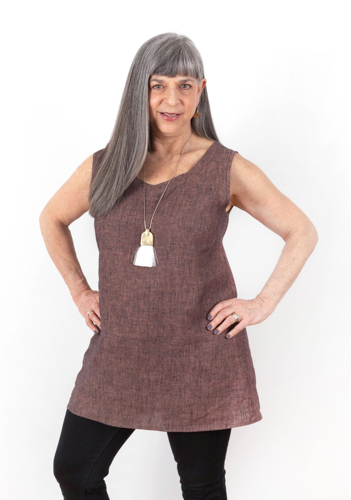 Front view of the Uniform Tunic sewn in sleeveless with v-neck, shown in red-brown linen on model.