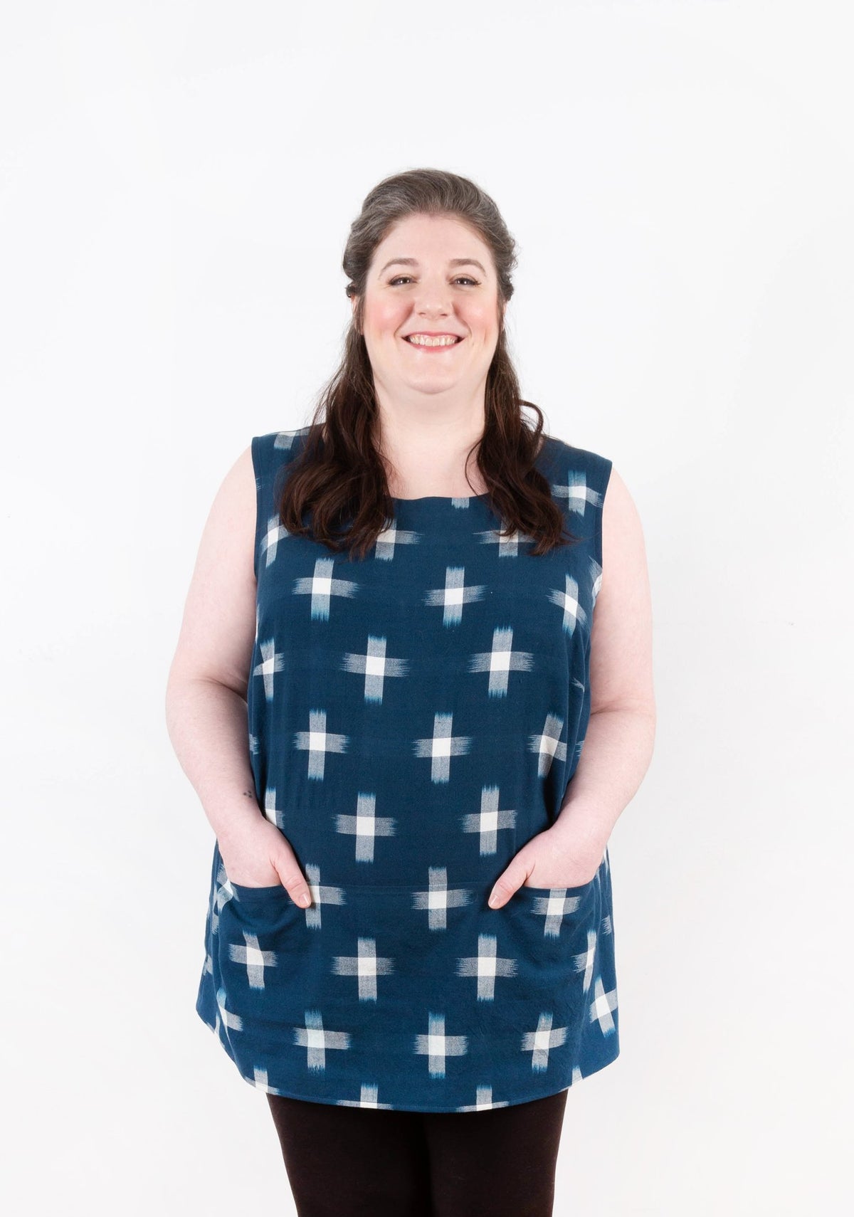 Model: Size 20, 5'5" | Front view of sleeveless Uniform Tunic in navy ikat print with patch pockets.