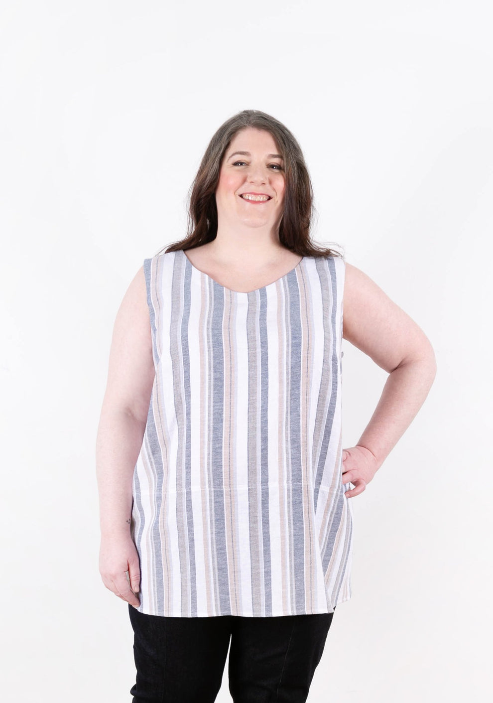 Front view of striped sleeveless Uniform Tunic with model's hand on hip.